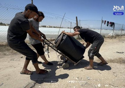 نازحون يتجمعون عند صنبور مياه في منطقة المواصي بمدينة خان يونس