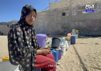 نازحون يتجمعون عند صنبور مياه في منطقة المواصي بمدينة خان يونس