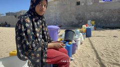 نازحون يتجمعون عند صنبور مياه في منطقة المواصي بمدينة خان يونس