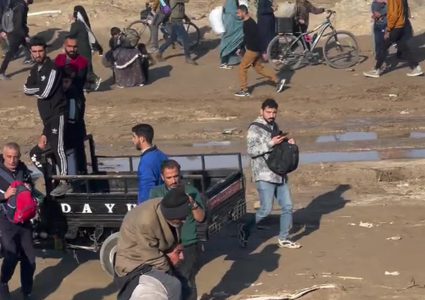 رغم طول المسافة... شاب فلسطيني يحمل والده ويشق طريق عودته مشيا على الأقدام إلى شمال قطاع غزة