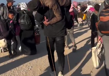 رغم طول المسافة... شاب فلسطيني يحمل والده ويشق طريق عودته مشيا على الأقدام إلى شمال قطاع غزة