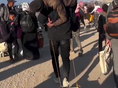 رغم طول المسافة... شاب فلسطيني يحمل والده ويشق طريق عودته مشيا على الأقدام إلى شمال قطاع غزة