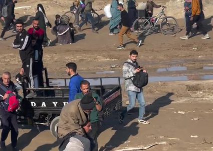 رغم طول المسافة... شاب فلسطيني يحمل والده ويشق طريق عودته مشيا على الأقدام إلى شمال قطاع غزة