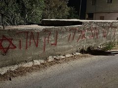 مستوطنون يحرقون مركبات ويخطّون شعارات تحريضية في رمون شرق رام الله