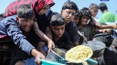 مواطنون يتجمعون أمام تكية خيرية؛ للحصول على قليل من الطعام، في ظل استمرار الحصار والمجاعة وحرب الإبادة بقطاع غزة,