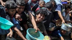 مواطنون يتجمعون أمام تكية خيرية؛ للحصول على قليل من الطعام، في ظل استمرار الحصار والمجاعة وحرب الإبادة بقطاع غزة,