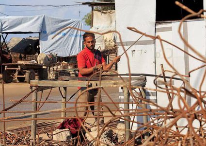 مواطنون غزيون يكافحون لاستخراج الحديد من المباني التي دمرها جيش الإحتلال الاسرائيلي للانتفاع بها في جهود الإيواء المحلية