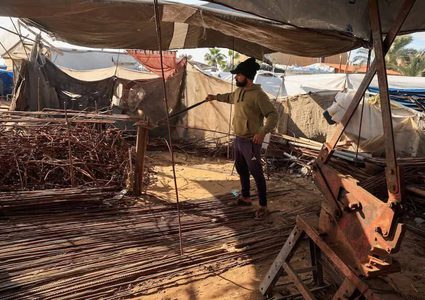 مواطنون غزيون يكافحون لاستخراج الحديد من المباني التي دمرها جيش الإحتلال الاسرائيلي للانتفاع بها في جهود الإيواء المحلية