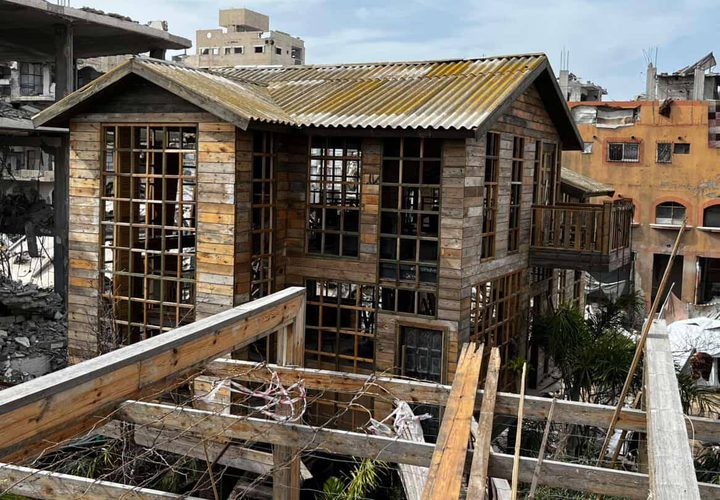 شاب يبني كوخًا خشبيًا مكان منزل مدمر بعزة