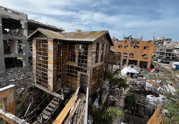 شاب يبني كوخًا خشبيًا مكان منزل مدمر بعزة