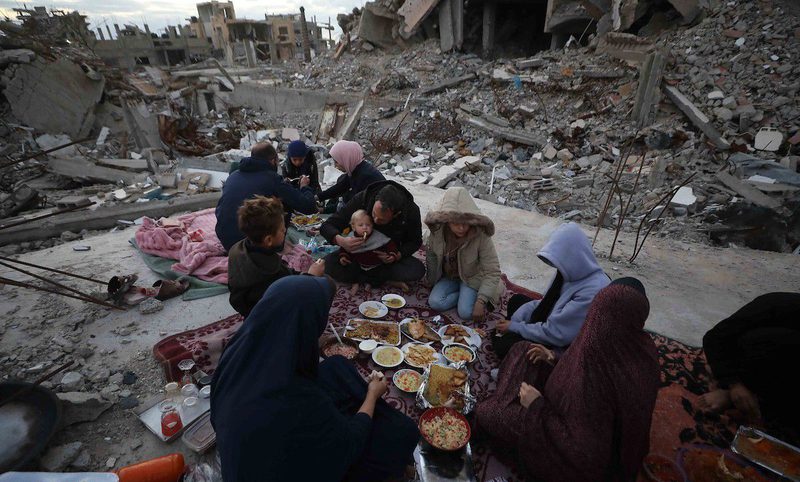 بالصور عائلة فلسطينية تتناول إفطارها خلال شهر رمضان على سطح منزلها الذي دمره قصف جوي إسرائيلي خلال حرب غزة