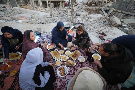 عائلة فلسطينية تتناول إفطارها في رمضان على سطح منزلها المدمر في غزة