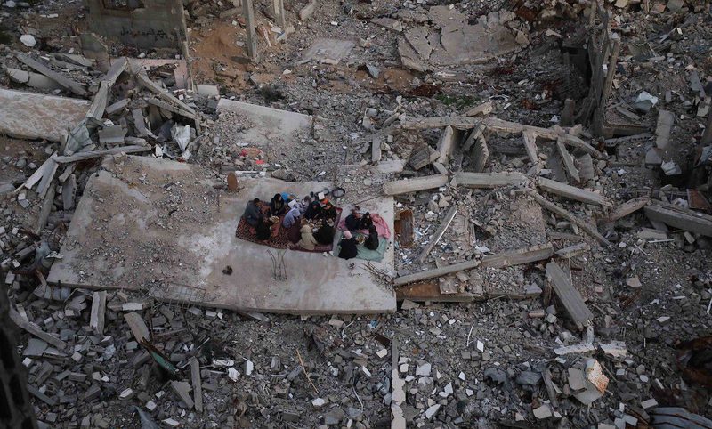 بالصور عائلة فلسطينية تتناول إفطارها خلال شهر رمضان على سطح منزلها الذي دمره قصف جوي إسرائيلي خلال حرب غزة