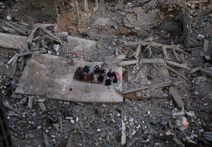 بالصور عائلة فلسطينية تتناول إفطارها خلال شهر رمضان على سطح منزلها الذي دمره قصف جوي إسرائيلي خلال حرب غزة