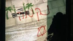آثار إحراق المستوطنين مركبة فلسطينية وكتابة شعارات عنصرية على الجدران في منطقة صافا ببلدة بيت أمر شمال الخليل.
