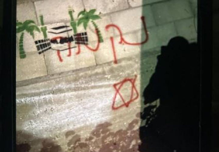 آثار إحراق المستوطنين مركبة فلسطينية وكتابة شعارات عنصرية على الجدران في منطقة صافا ببلدة بيت أمر شمال الخليل.