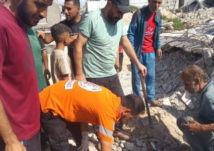 طواقم الدفاع المدني تنتشل رفات شهيد من منطقة حي الأمل بمدينة خان يونس، وتنقله إلى مجمع ناصر الطبي.